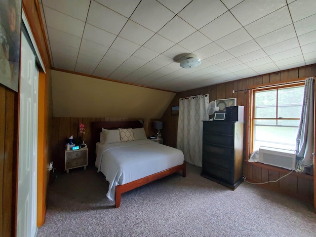 unfurnished bedroom featuring carpet, lofted ceiling, and wood walls