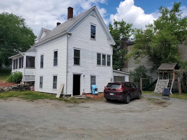 back of house featuring a playground