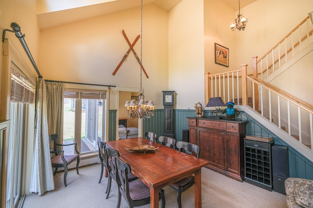 carpeted dining area with high vaulted ceiling and a notable chandelier