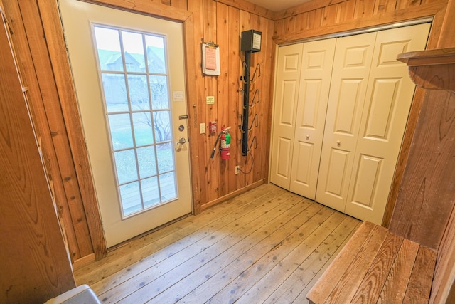 doorway featuring wooden walls and light hardwood / wood-style flooring