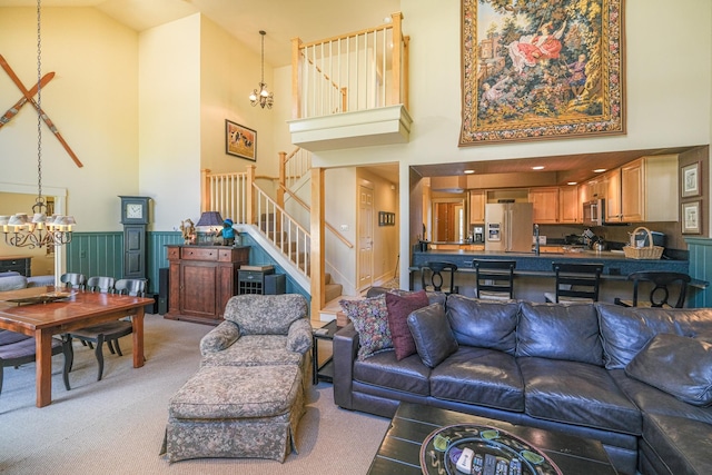 carpeted living room featuring a high ceiling and a notable chandelier