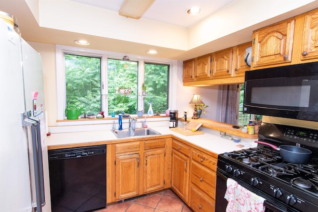 kitchen with sink, light tile patterned floors, and black appliances