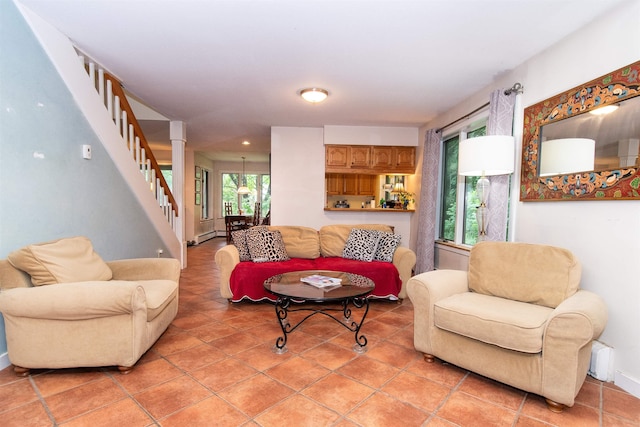 living room with a baseboard radiator, light tile patterned floors, and ornate columns