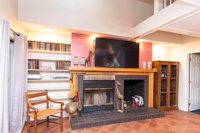 living room featuring a tiled fireplace and tile patterned flooring