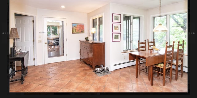 dining area with a baseboard heating unit, washer / dryer, and light tile patterned floors