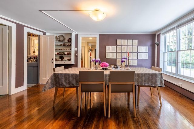 dining space featuring hardwood / wood-style floors and crown molding