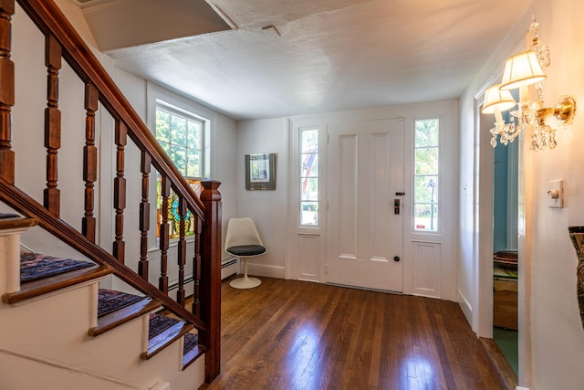 entrance foyer featuring stairway, baseboards, a textured ceiling, and wood finished floors