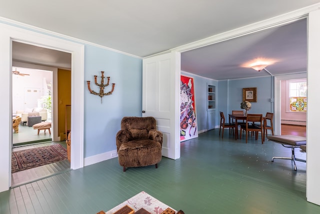 sitting room featuring baseboard heating, wood finished floors, and ornamental molding