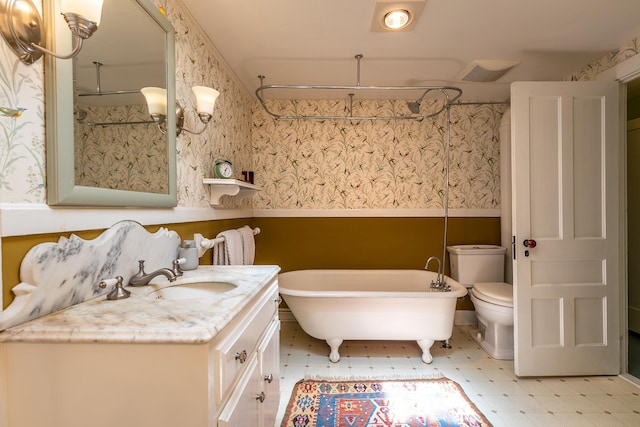 bathroom with tile patterned floors, a freestanding bath, vanity, and wallpapered walls