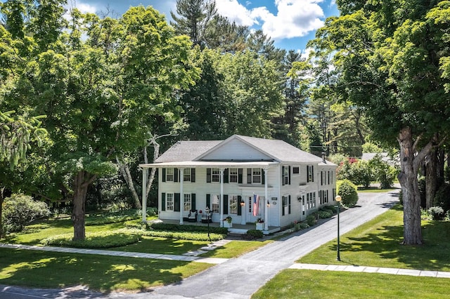 view of front of house with driveway, a porch, and a front lawn