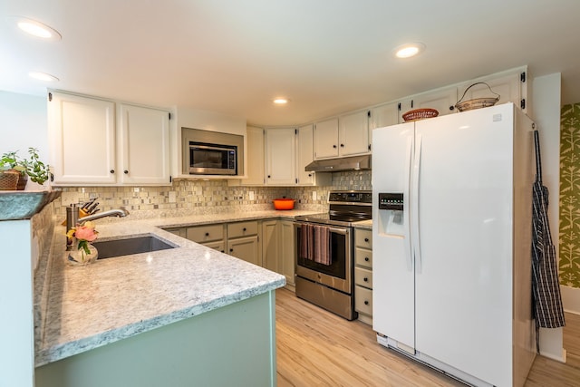 kitchen with a sink, decorative backsplash, stainless steel appliances, under cabinet range hood, and light wood-type flooring