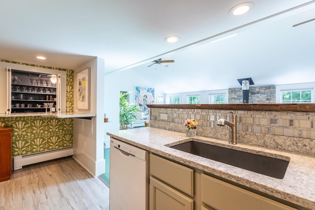 kitchen with tasteful backsplash, baseboard heating, dishwasher, and a sink