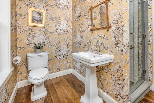 bathroom with a shower, hardwood / wood-style floors, and toilet