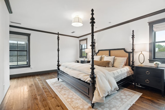 bedroom with dark hardwood / wood-style flooring and crown molding