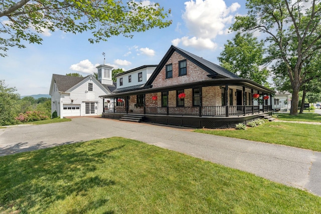 view of front of house with a porch, a garage, and a front lawn