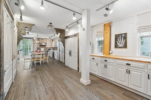 kitchen featuring white cabinetry, plenty of natural light, and butcher block counters