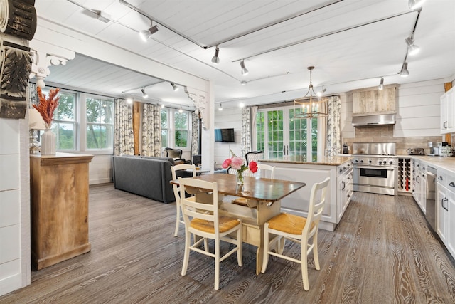 kitchen with hardwood / wood-style floors, white cabinets, stainless steel appliances, and a kitchen island