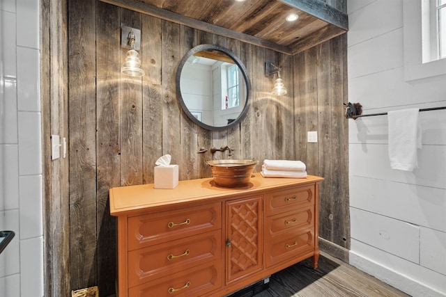 bathroom with vanity, wood walls, and wood ceiling