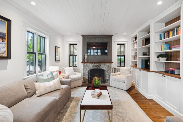 living room featuring built in features, dark hardwood / wood-style floors, crown molding, a fireplace, and wood ceiling