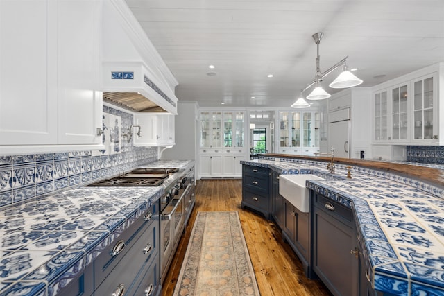 kitchen with pendant lighting, sink, tasteful backsplash, dark hardwood / wood-style flooring, and white cabinetry