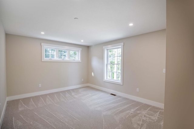 spare room featuring light colored carpet