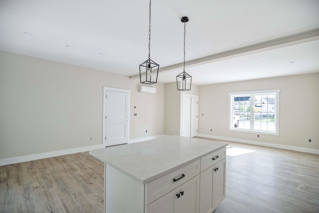 kitchen with decorative light fixtures, white cabinetry, a center island, light hardwood / wood-style floors, and a wall unit AC