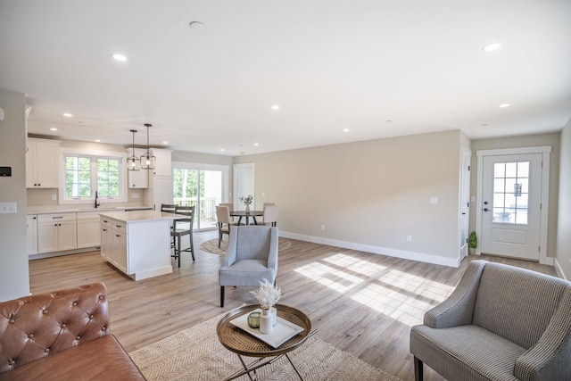 living room with sink and light wood-type flooring