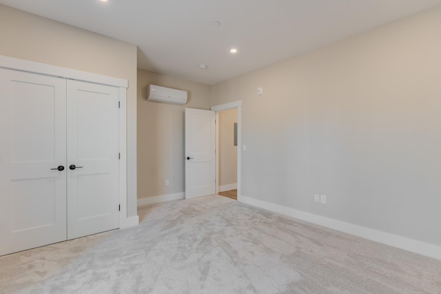 unfurnished bedroom featuring light carpet, a wall mounted air conditioner, and a closet