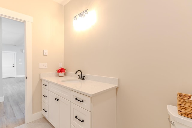 bathroom featuring vanity, hardwood / wood-style floors, and toilet