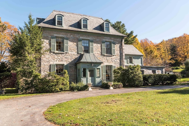 colonial inspired home with a front lawn