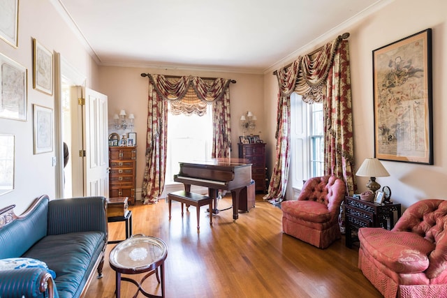 sitting room with crown molding and hardwood / wood-style floors