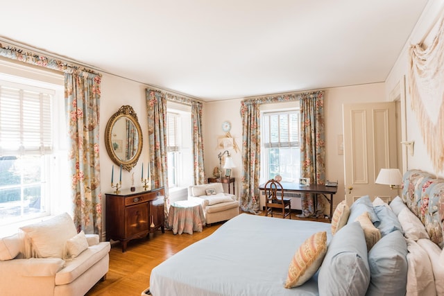 bedroom featuring radiator heating unit and light hardwood / wood-style floors