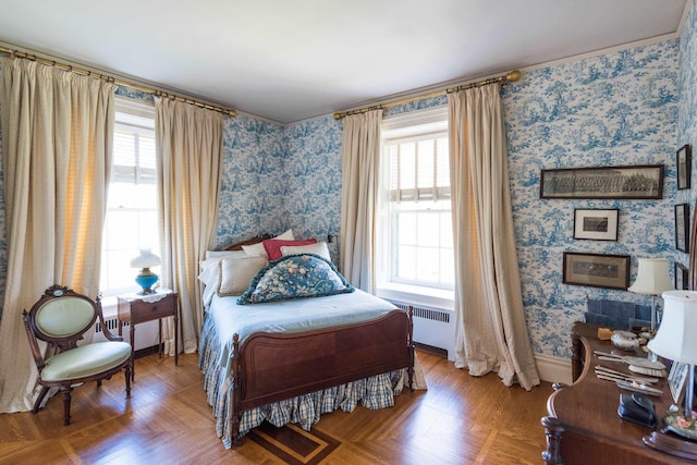 bedroom featuring wood-type flooring, radiator, and multiple windows