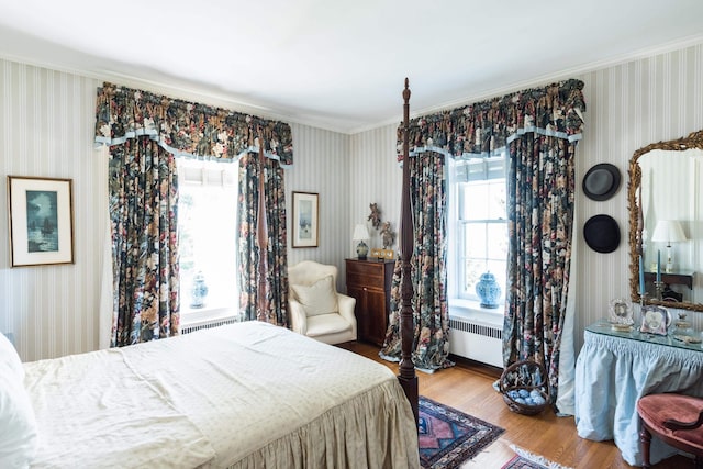 bedroom featuring radiator heating unit and hardwood / wood-style floors