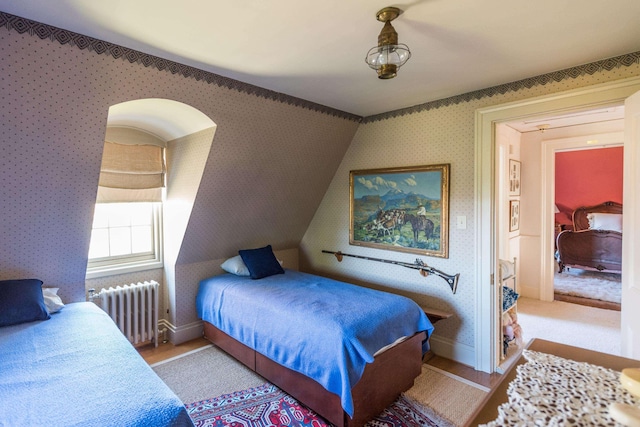 bedroom featuring radiator and light hardwood / wood-style floors