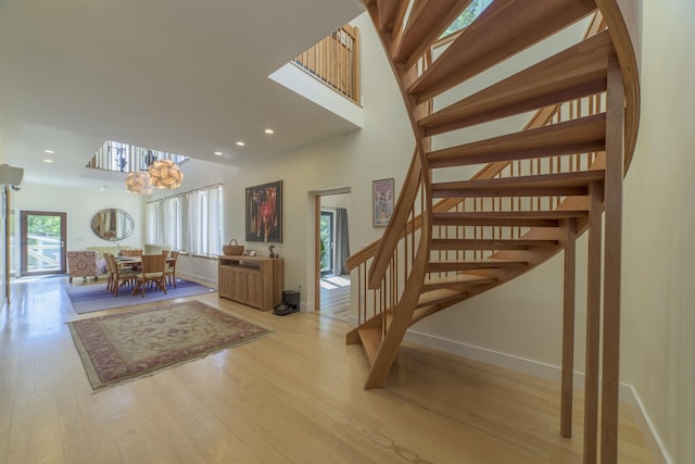 stairs featuring a chandelier and wood-type flooring