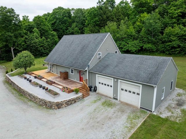 view of front of property with a garage, a deck, and a front yard