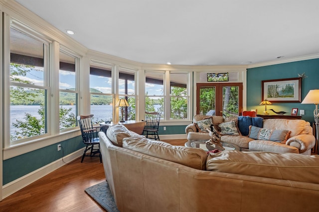 living room with plenty of natural light, french doors, a water view, and wood finished floors