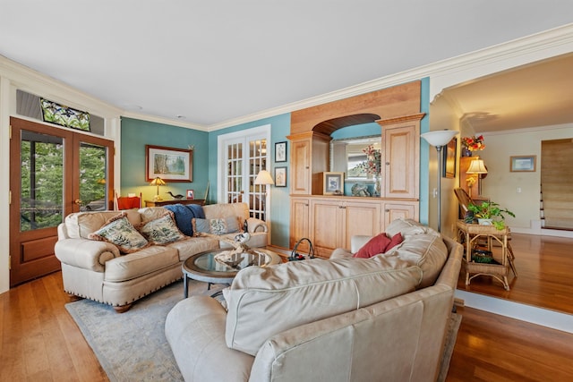 living room featuring french doors, light hardwood / wood-style flooring, crown molding, and ornate columns