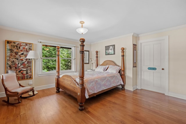 bedroom featuring light wood-type flooring, baseboards, and ornamental molding