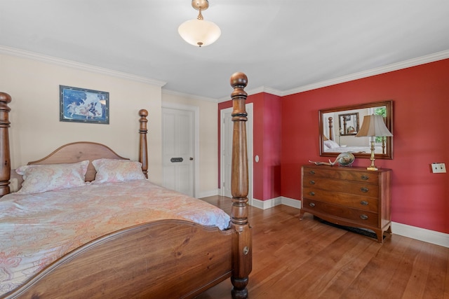 bedroom featuring crown molding, baseboards, and hardwood / wood-style flooring