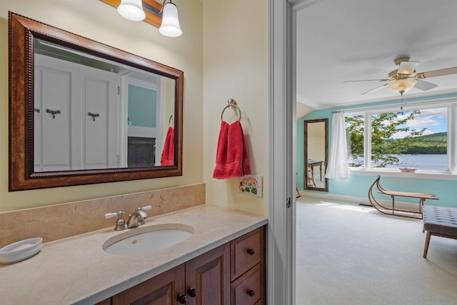 bathroom with vaulted ceiling, vanity, and a ceiling fan