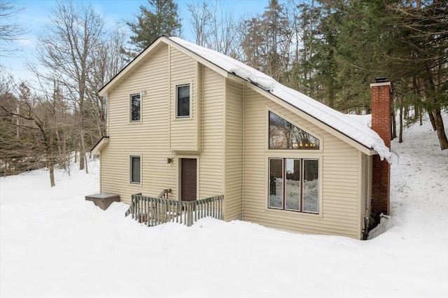 snow covered house with a chimney