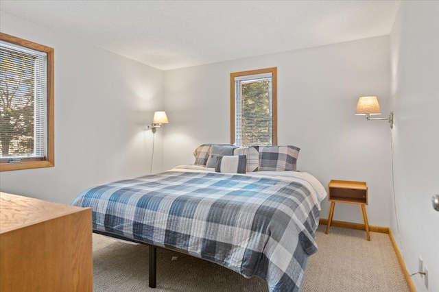 bedroom featuring baseboards and light colored carpet