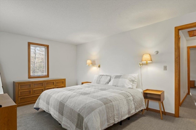 bedroom with carpet, baseboards, and a textured ceiling