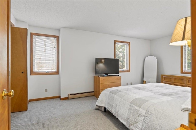 bedroom with a textured ceiling, a baseboard radiator, carpet flooring, and baseboards