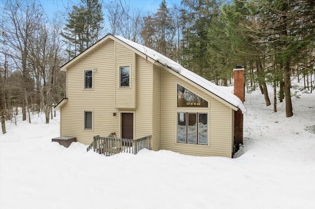 snow covered property featuring a chimney