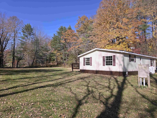 view of property exterior featuring a yard and a wooden deck