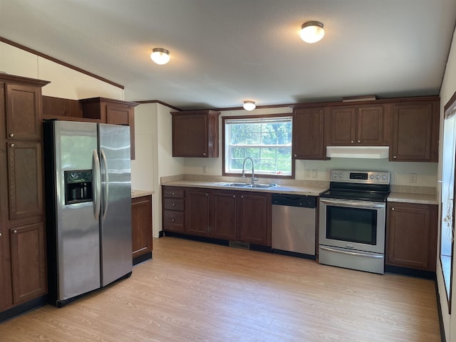 kitchen featuring appliances with stainless steel finishes, light hardwood / wood-style flooring, ornamental molding, and sink