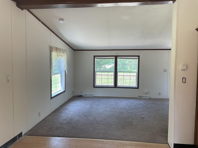 spare room featuring hardwood / wood-style floors and lofted ceiling with beams